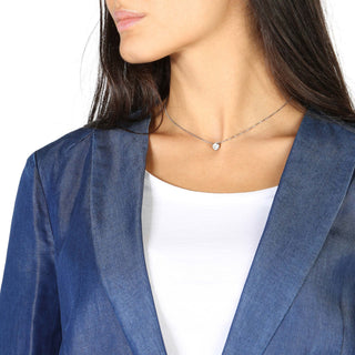 Woman’s denim blazer with a white top and a delicate necklace.